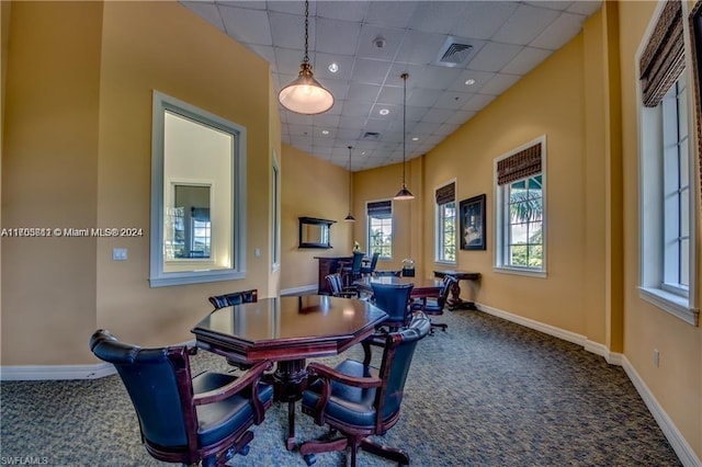 dining area featuring carpet and a drop ceiling