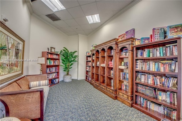 living area featuring carpet flooring, a drop ceiling, and crown molding