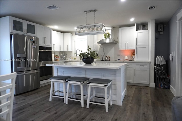 kitchen featuring white cabinets, decorative light fixtures, and stainless steel appliances