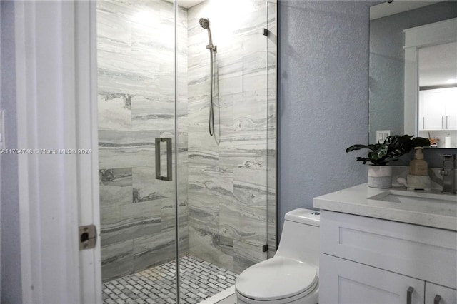 bathroom with vanity, toilet, and a shower with door