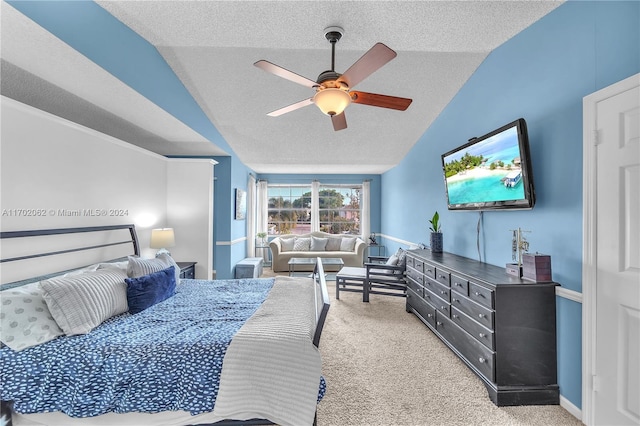 carpeted bedroom featuring a textured ceiling, vaulted ceiling, and ceiling fan