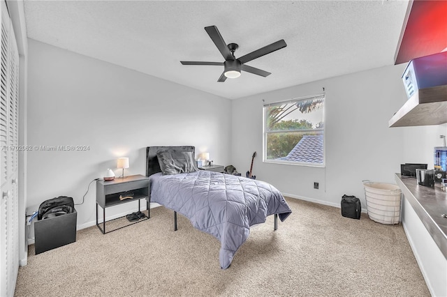 bedroom featuring carpet, ceiling fan, and a textured ceiling