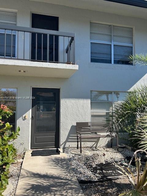 view of exterior entry featuring a balcony