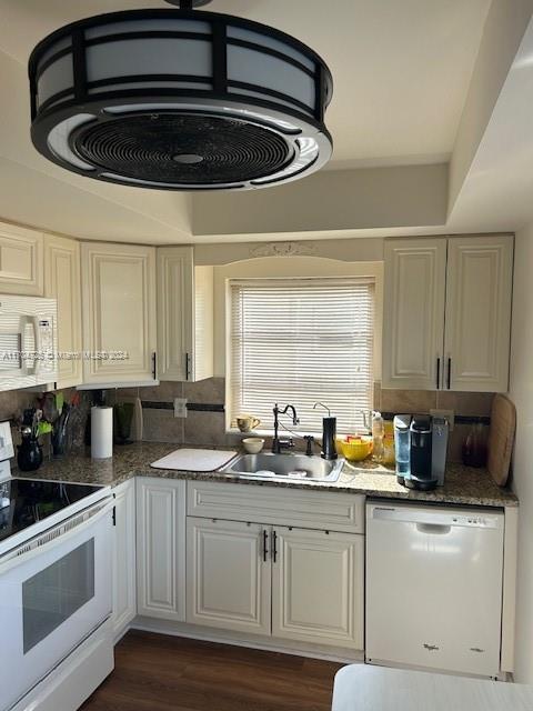 kitchen featuring white appliances, sink, decorative backsplash, dark hardwood / wood-style flooring, and white cabinetry