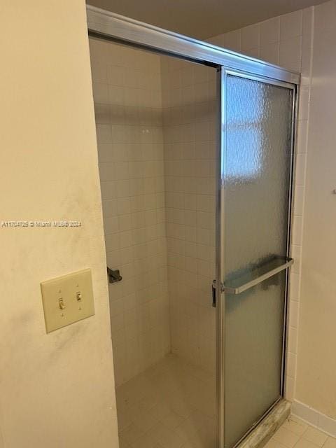 bathroom with tile patterned flooring and an enclosed shower