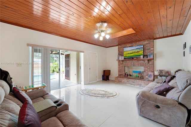 tiled living room featuring ceiling fan, wooden ceiling, a fireplace, and a skylight