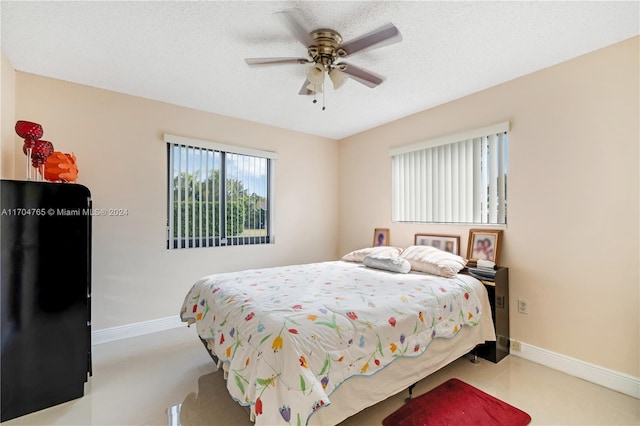 bedroom with ceiling fan and a textured ceiling