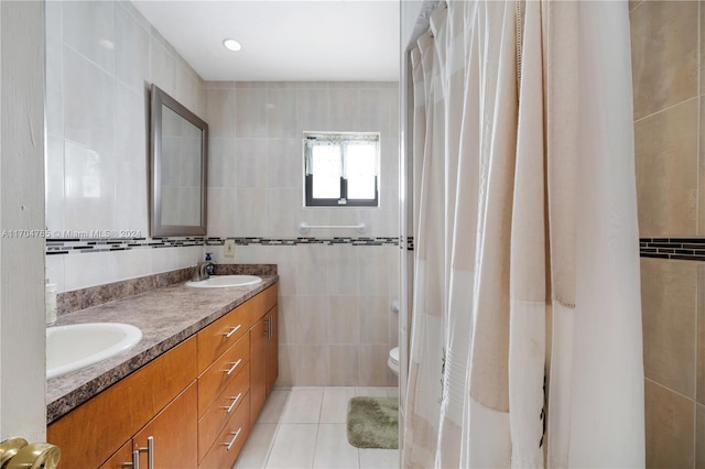 bathroom featuring tile patterned flooring, vanity, tile walls, and toilet