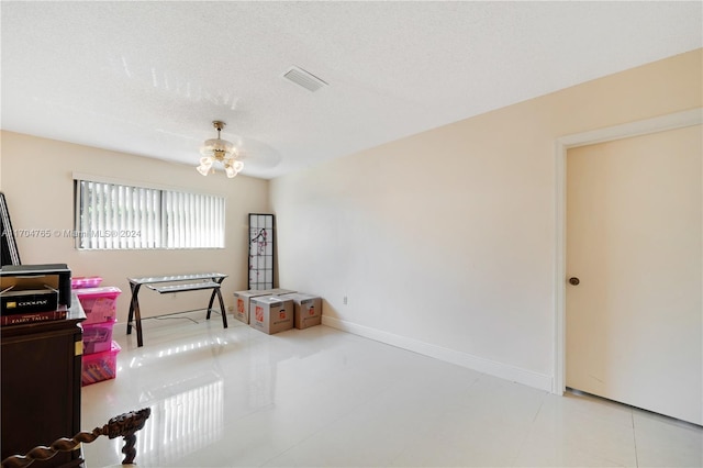 miscellaneous room with ceiling fan and a textured ceiling