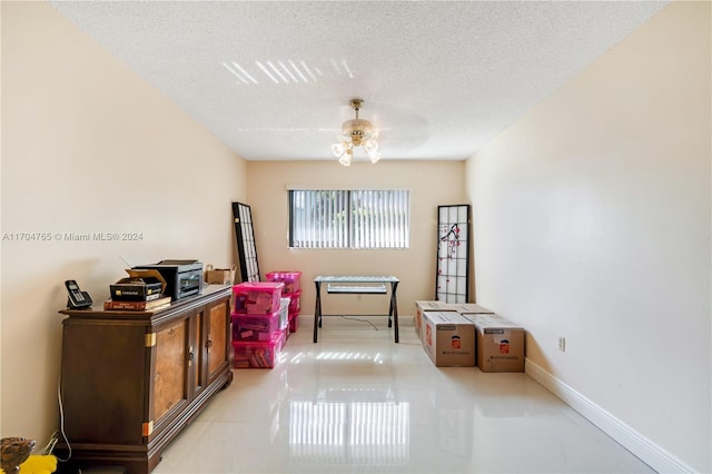 misc room with ceiling fan and a textured ceiling