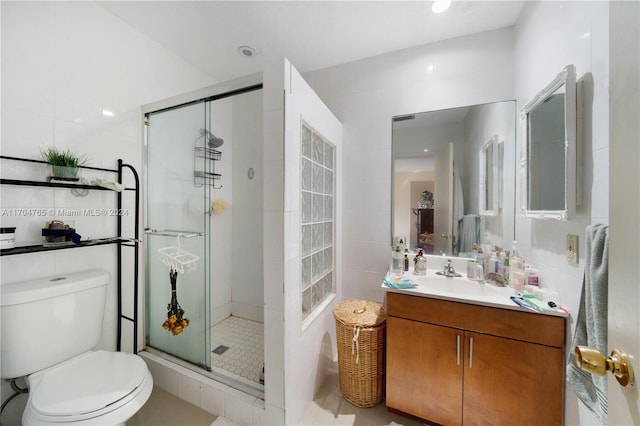 bathroom featuring toilet, a shower with door, and tile walls