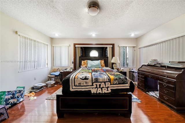 bedroom with hardwood / wood-style floors and a textured ceiling