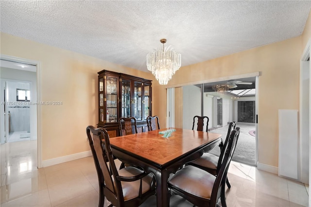 dining room with light tile patterned flooring, a textured ceiling, and an inviting chandelier