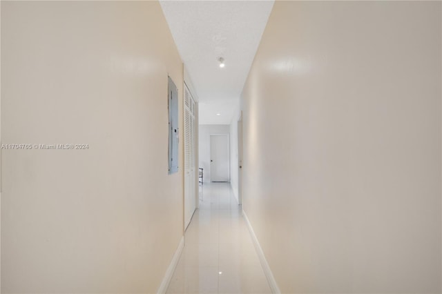 hall featuring light tile patterned floors and electric panel