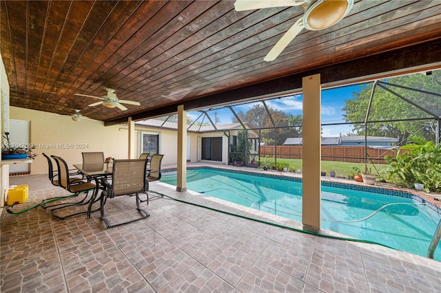 view of swimming pool featuring a patio area, ceiling fan, and glass enclosure