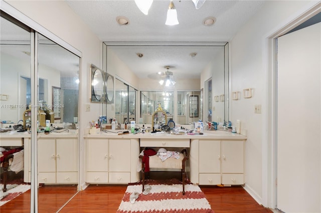 bathroom featuring hardwood / wood-style floors, vanity, an enclosed shower, and a textured ceiling