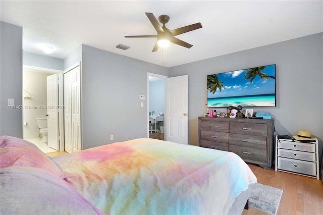 bedroom with ceiling fan, ensuite bathroom, and light wood-type flooring