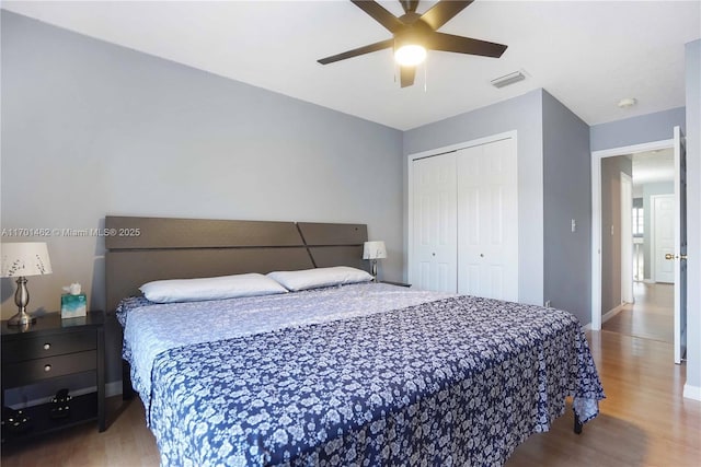 bedroom with hardwood / wood-style floors, a closet, and ceiling fan