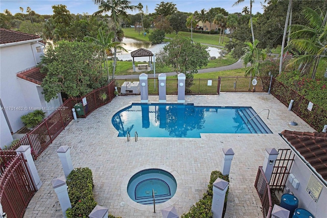 view of swimming pool with a hot tub