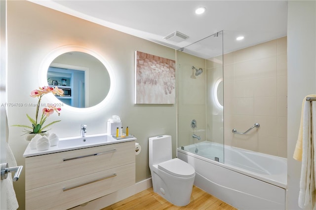 full bathroom featuring hardwood / wood-style floors, vanity, toilet, and enclosed tub / shower combo