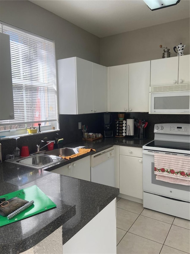 kitchen with sink, white appliances, white cabinets, and light tile patterned flooring