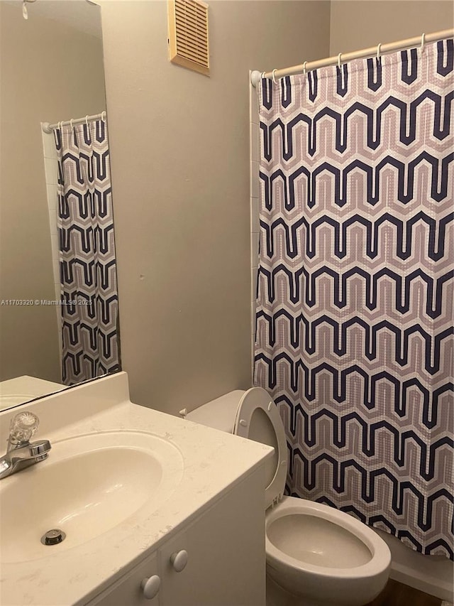 bathroom featuring vanity, a shower with shower curtain, and toilet