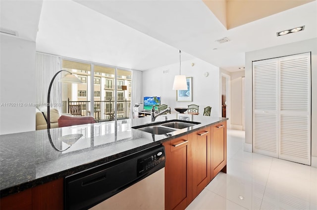 kitchen with stainless steel dishwasher, dark stone counters, sink, light tile patterned floors, and hanging light fixtures