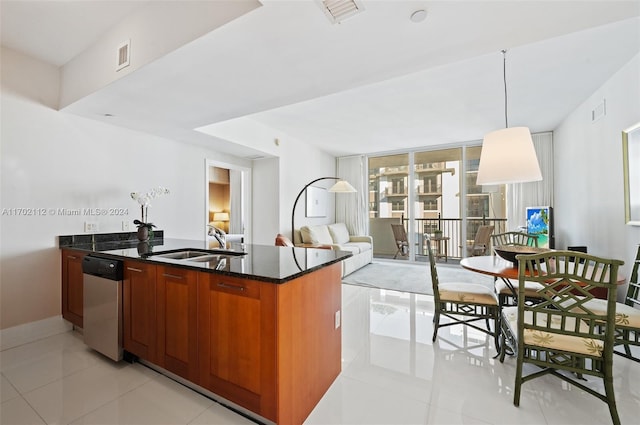 kitchen featuring floor to ceiling windows, sink, stainless steel dishwasher, decorative light fixtures, and light tile patterned floors