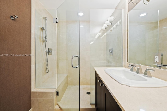 bathroom featuring vanity and a shower with door