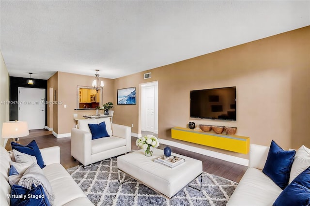 living room featuring wood-type flooring and an inviting chandelier