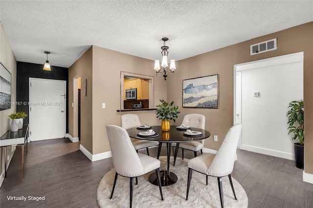 dining room featuring a notable chandelier and a textured ceiling