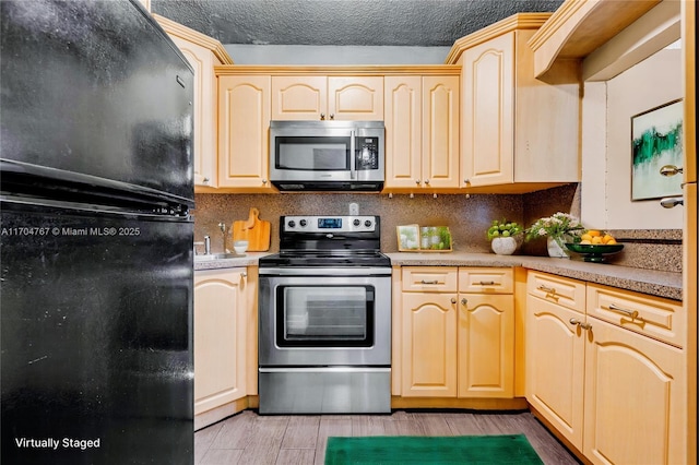 kitchen featuring decorative backsplash, appliances with stainless steel finishes, a textured ceiling, and light brown cabinets