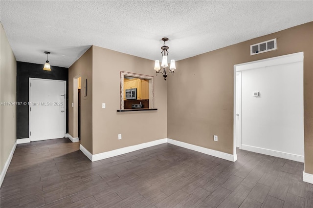 interior space with a notable chandelier and a textured ceiling