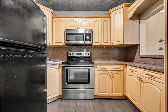 kitchen with sink, stainless steel appliances, backsplash, a textured ceiling, and light brown cabinetry