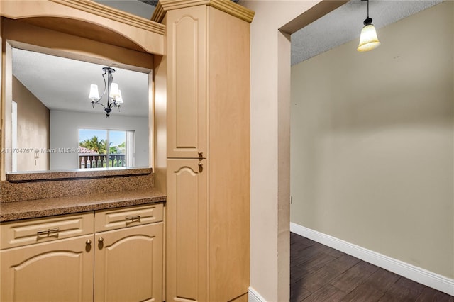 kitchen featuring an inviting chandelier, a textured ceiling, and cream cabinetry