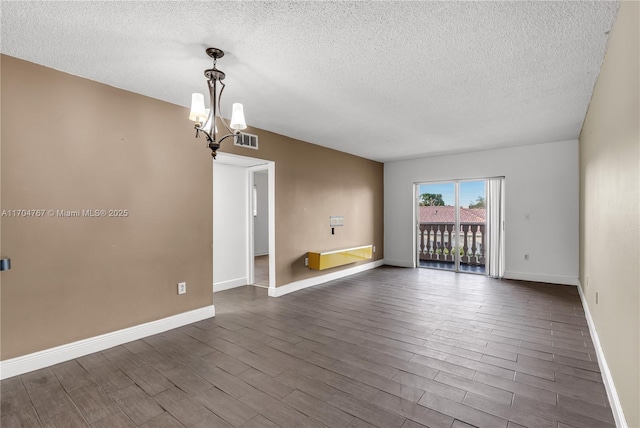 unfurnished room with a textured ceiling and an inviting chandelier