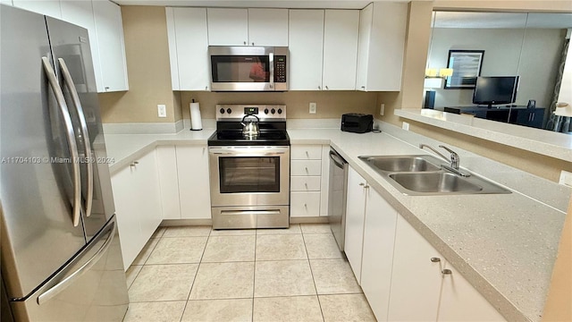 kitchen featuring sink, white cabinetry, stainless steel appliances, and light tile patterned floors