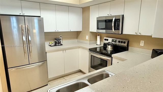 17375 Collins Ave Unit 2406, Sunny Isles Beach, FL 33160 - kitchen with appliances with stainless steel finishes, white cabinetry, and light stone countertops