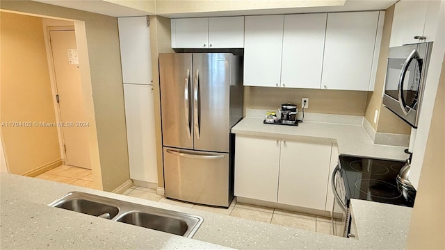 17375 Collins Ave Unit 2406, Sunny Isles Beach, FL 33160 - kitchen featuring stainless steel appliances, light tile patterned floors, light countertops, and white cabinetry