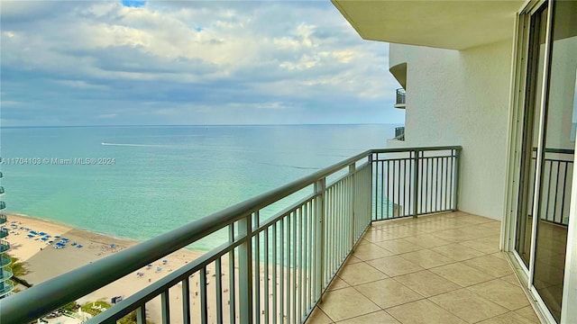 balcony with a water view and a view of the beach