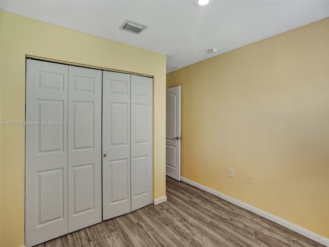 unfurnished bedroom featuring light wood-type flooring and a closet