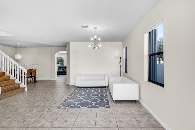 unfurnished living room with light tile patterned floors and an inviting chandelier