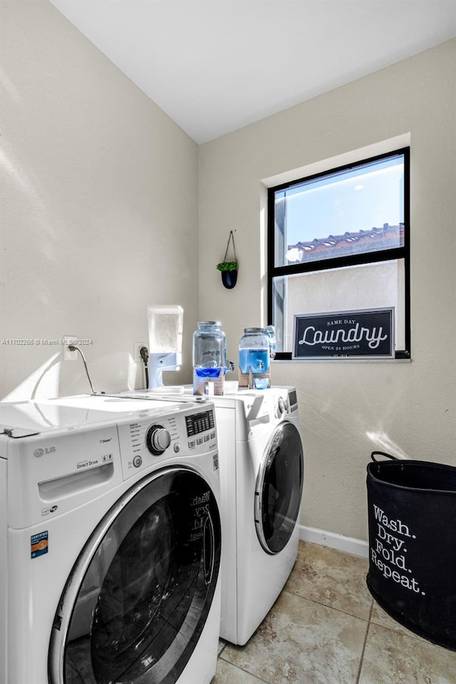 laundry area featuring washing machine and dryer and light tile patterned flooring