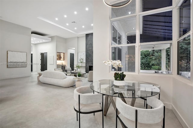 dining area with concrete flooring and a towering ceiling