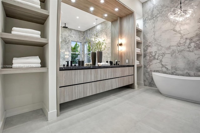 bathroom with vanity, a tub to relax in, and tile walls