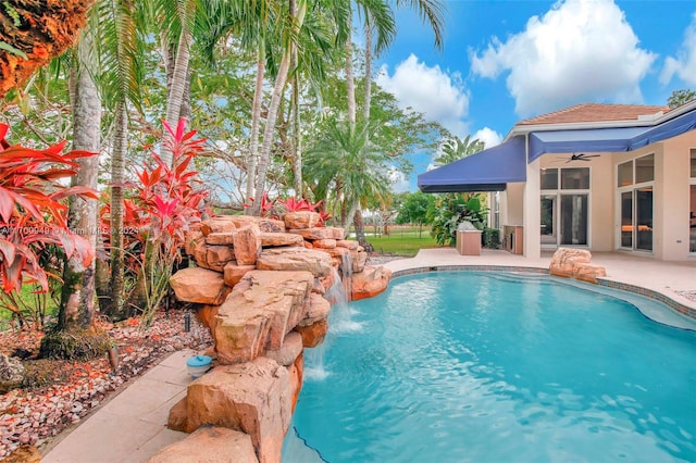 view of pool featuring pool water feature, ceiling fan, and a patio