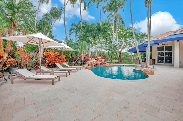 view of swimming pool with ceiling fan and a patio