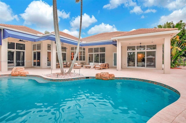 view of pool with an outdoor living space, a patio, and ceiling fan