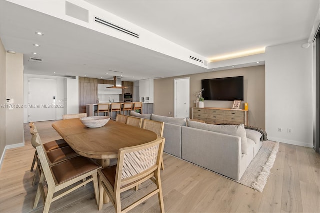 dining area featuring baseboards, visible vents, and light wood-style floors