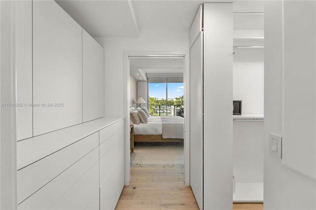 bedroom featuring light wood-type flooring, access to outside, and expansive windows